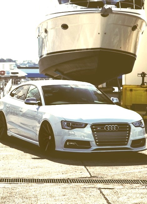 White Audi Infront of a Yacht